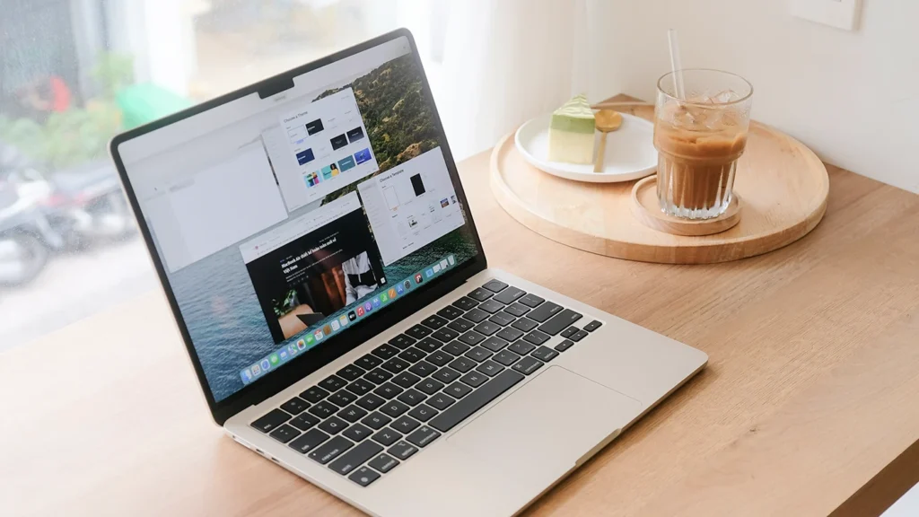 木のデスクにMacbookとアイスコーヒーとスイーツ