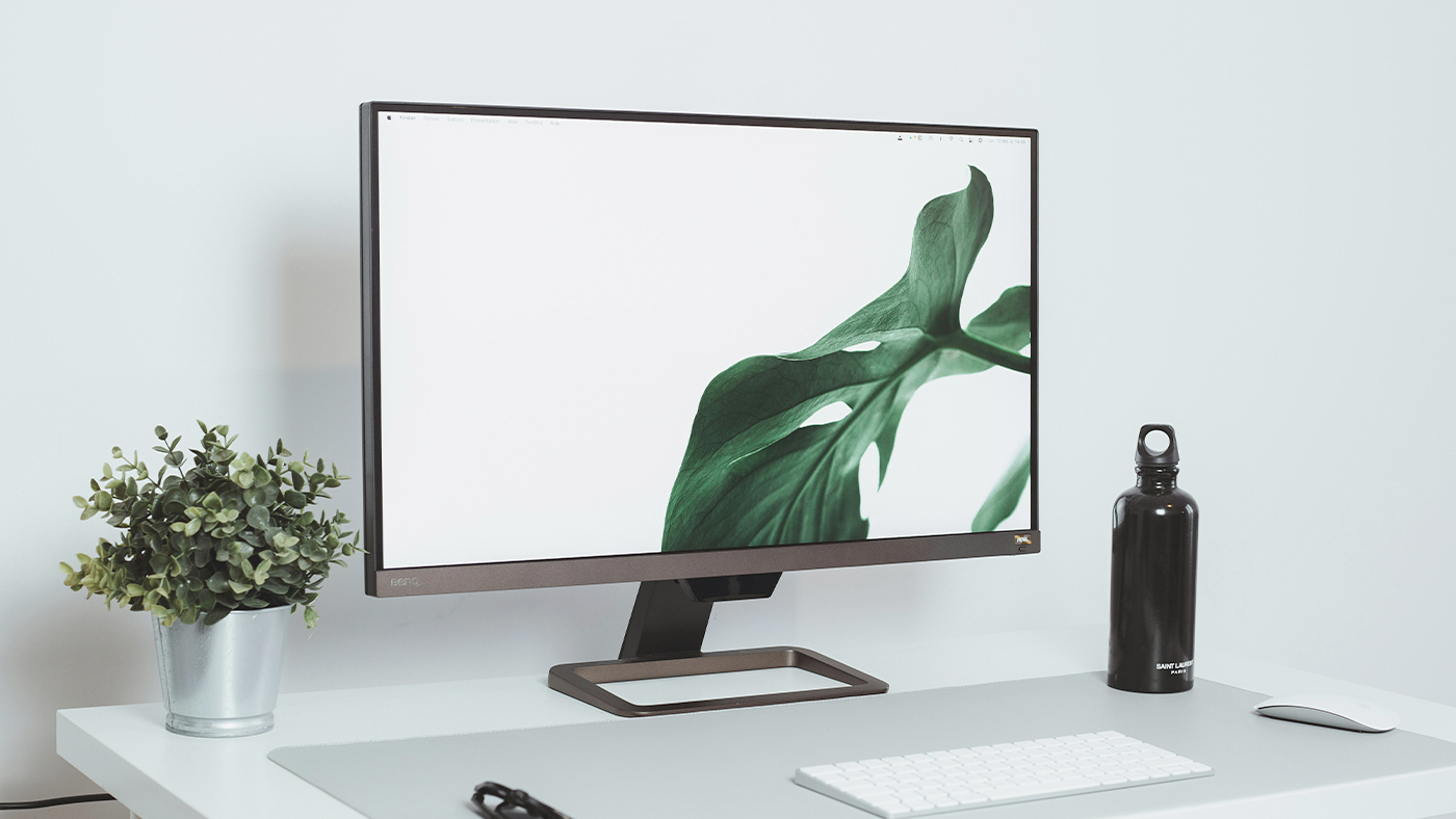 白い背景にデスクトップパソコンと緑の植物